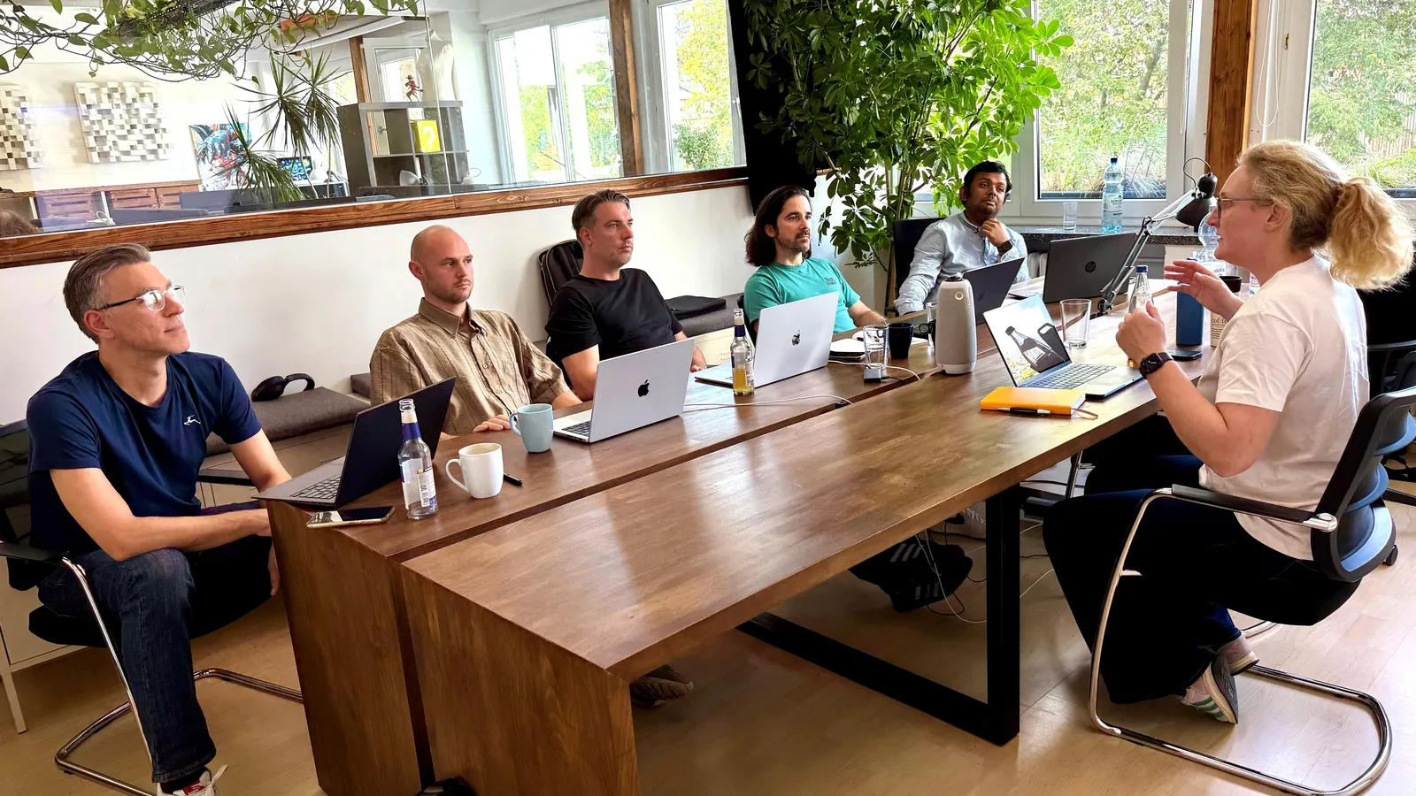 Microsoft Copilot Training im Trainingsraum der Copilotenschule in Köln-Nippes: Trainerin im Gespräch mit fünf Teilnehmenden am Schulungstisch